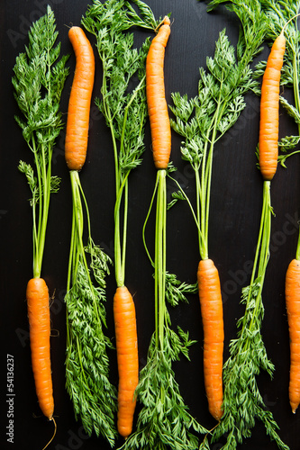 Fresh carrots on a black wooden table