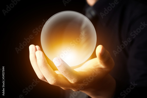 Businessman hand holding a Crystal Ball photo