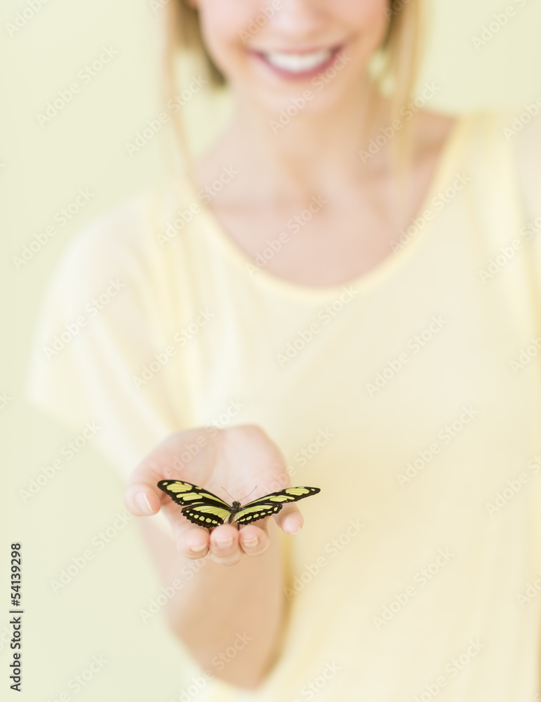 Obraz premium Close-Up Of Young Woman Holding Butterfly In Palm