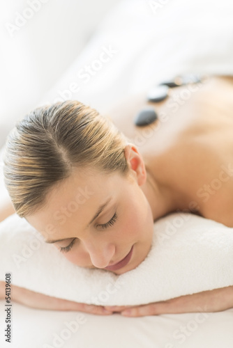 Woman Getting Hot Stone Therapy At Health Spa