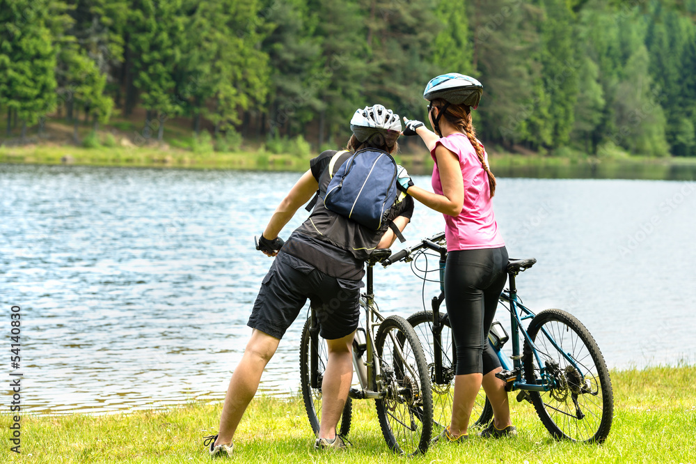 Young bikers at lake watching the forest