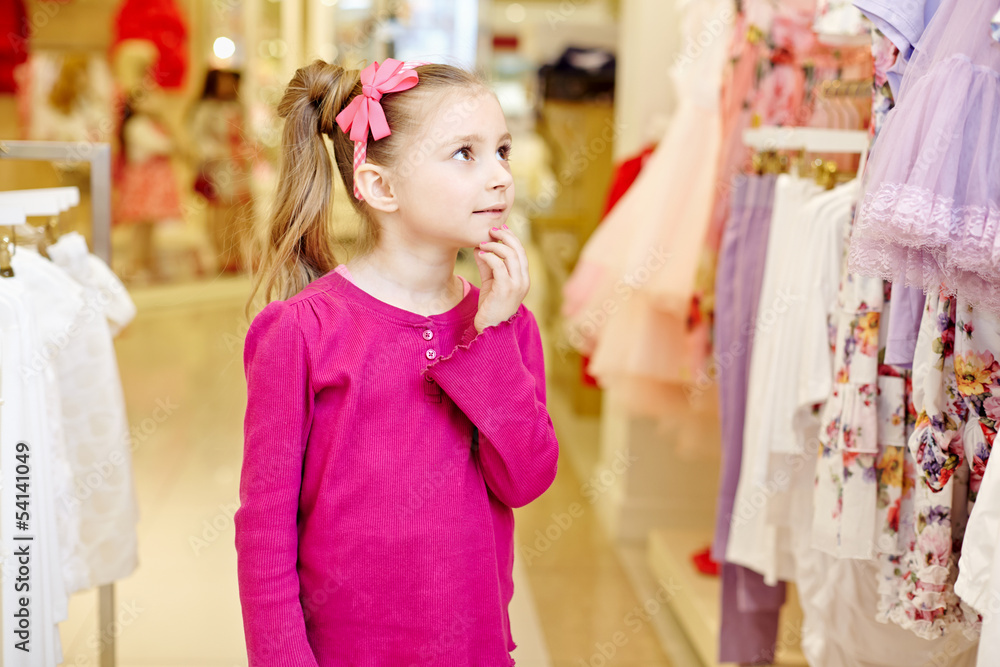 Little girl looks, touching chin with fingers Little girl looks, touching chin with fingers