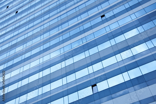 modern facade reflecting blue sky with open windows