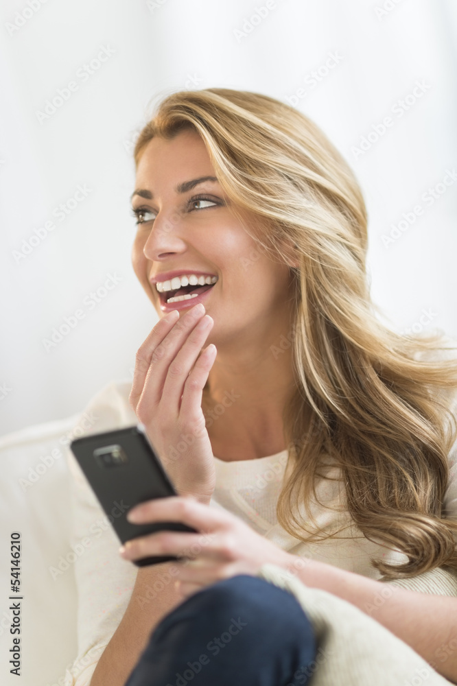Woman With Mobile Phone Looking Away At Home Woman With Mobile Phone Looking Away At Home