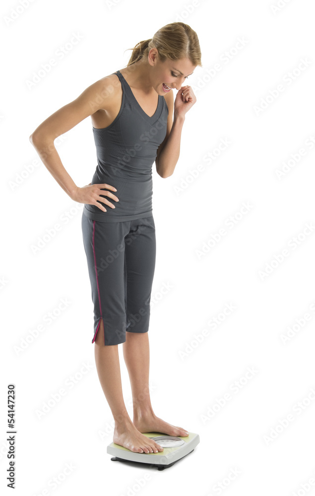 Fototapeta premium Happy Woman Weighing Herself On Weight Scale