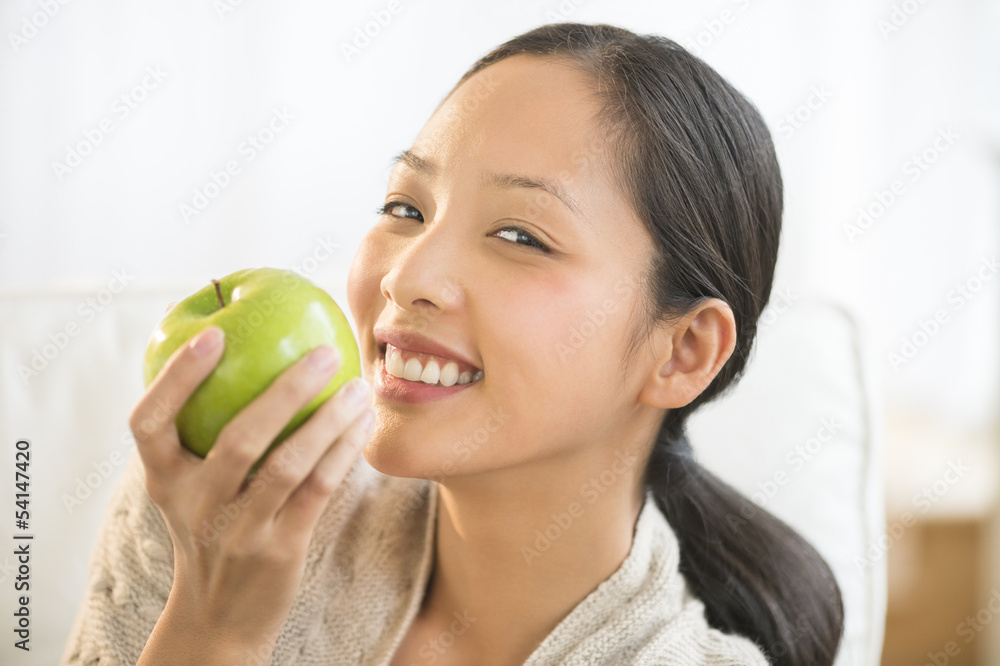 Woman Eating Granny Smith Apple On Sofa Woman Eating Granny Smith Apple On Sofa