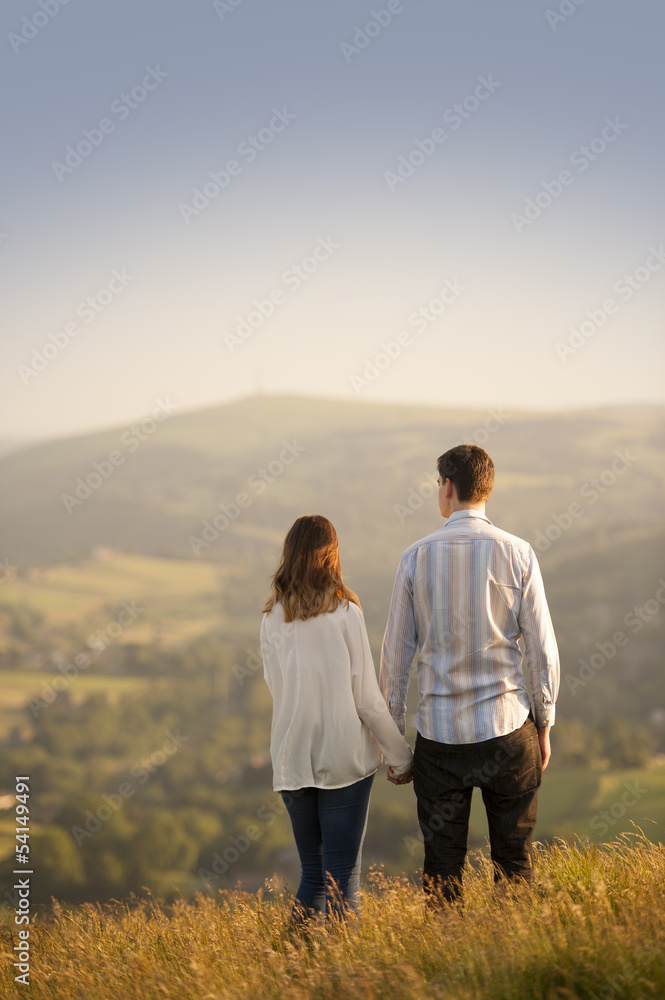 young couple look out over a beautiful landscape