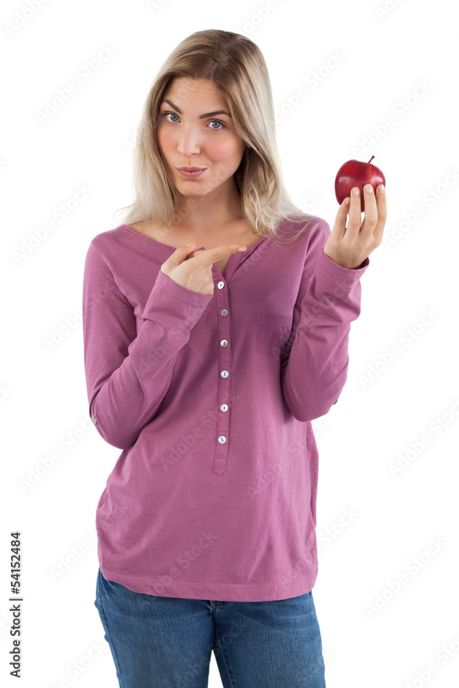 Blonde woman pointing to apple with her finger Blonde woman pointing to apple with her finger