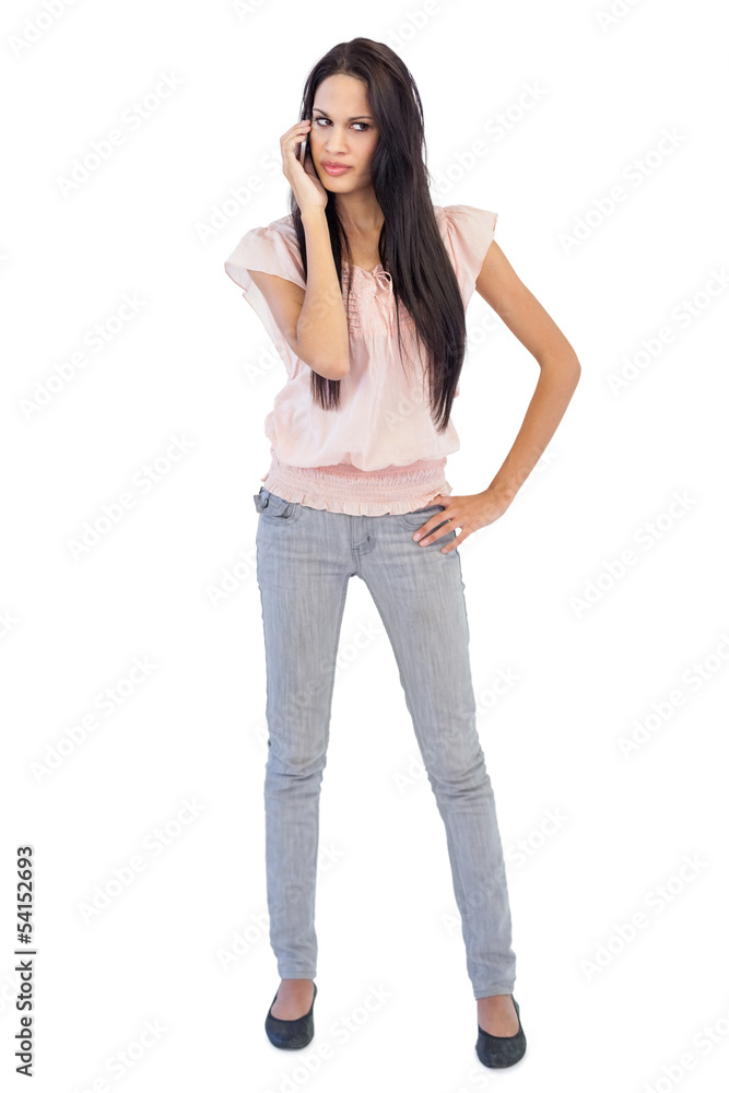 Serious woman calling someone with her mobile phone Serious woman calling someone with her mobile phone