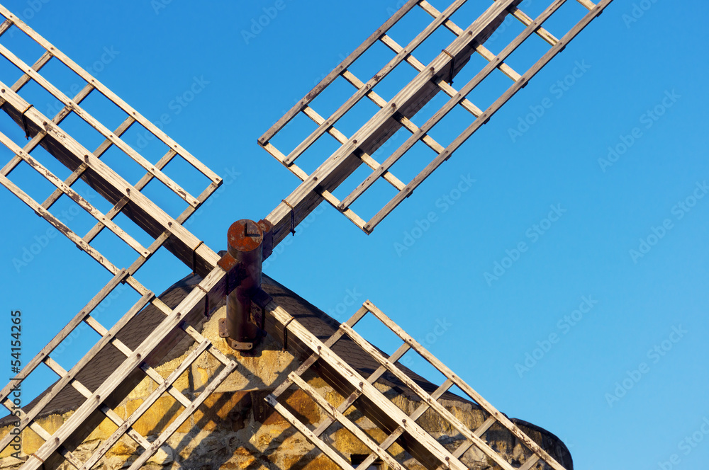 windmill with blades against blue sky