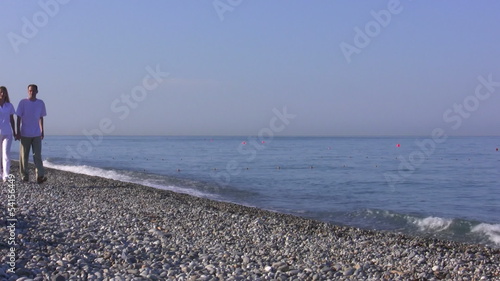 Young woman and the man go on seaside