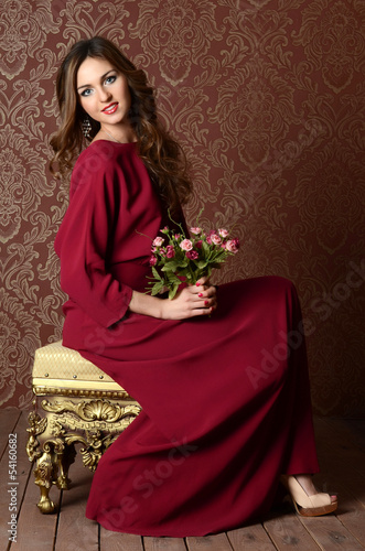 The elegant sensual young woman in a claret dress