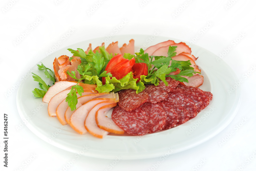Pastrami and salami slices decorated with greens and tomato.