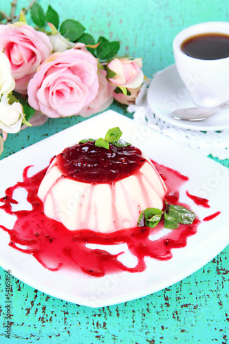Panna Cotta with raspberry sauce  on color wooden background