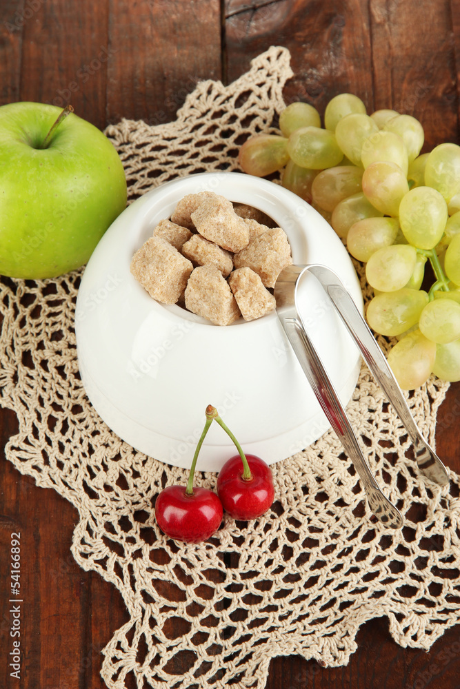Unrefined sugar in white sugar bowl on wooden background Unrefined sugar in white sugar bowl on wooden background