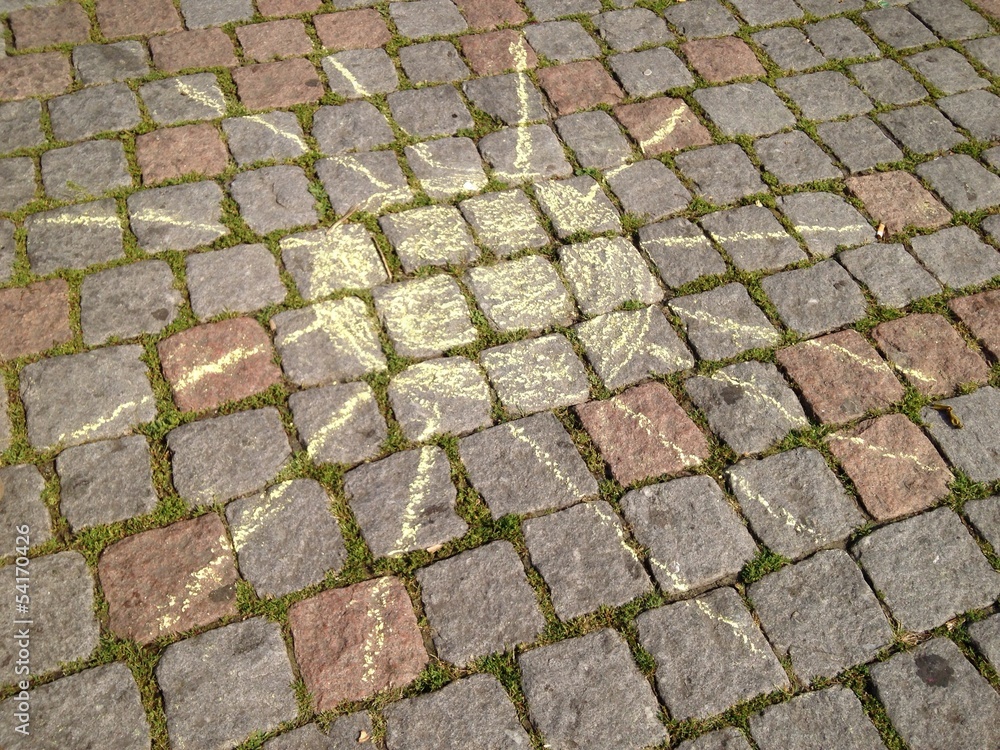 Sonne aus Kreide auf Pflastersteinen Sonne aus Kreide auf Pflastersteinen