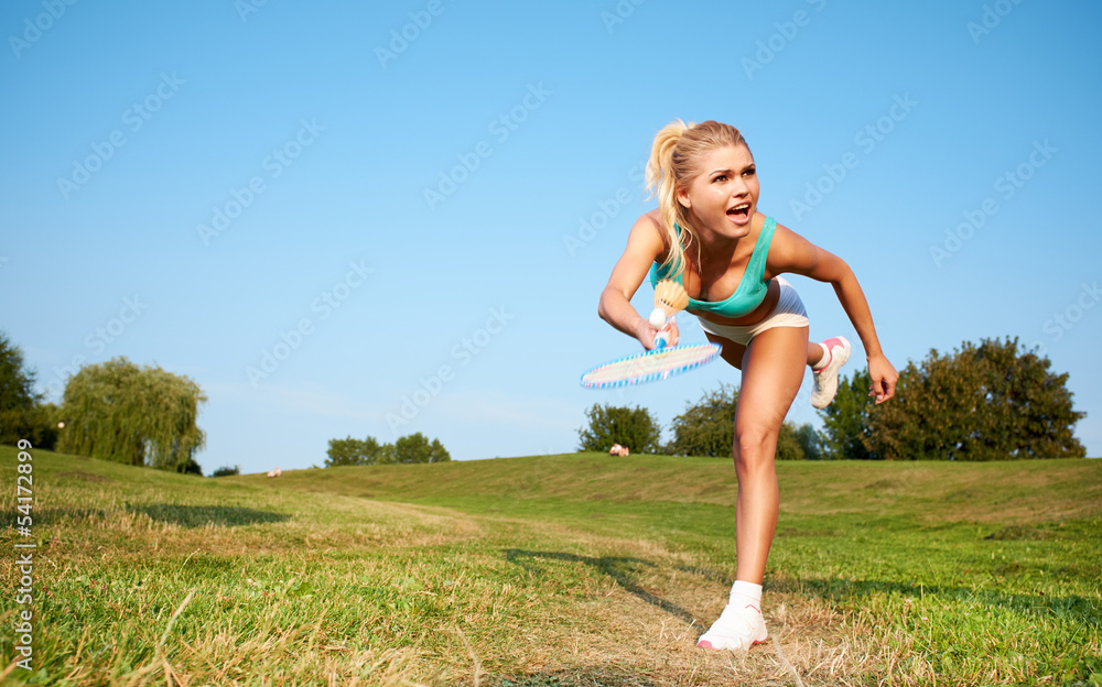Fitness, young woman playing badminton in a city park Fitness, young woman playing badminton in a city park