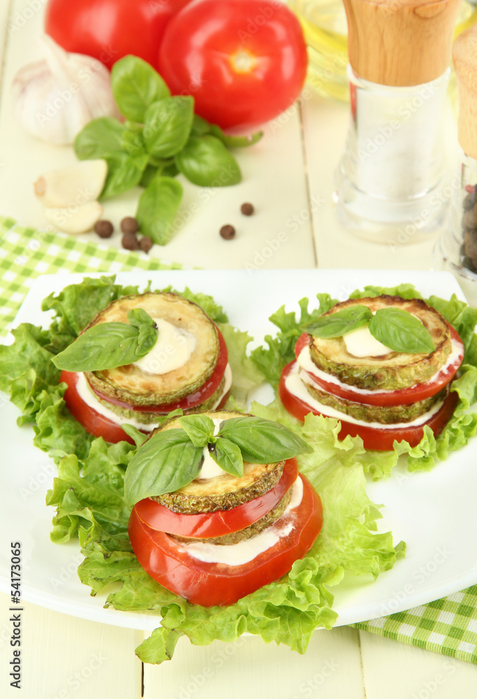 Tasty roasted marrow and tomato slices with salad leaves,