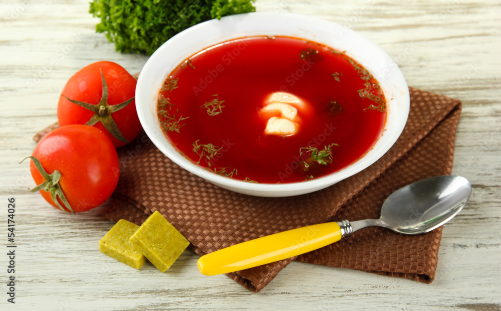 Bowl of soup with bouillon cubes on wooden table Bowl of soup with bouillon cubes on wooden table