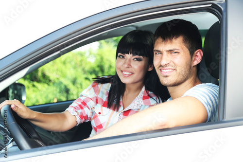 Beautiful happy young couple driving car