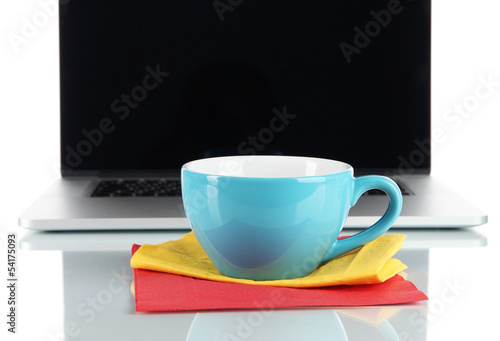 Blue cup on napkin on laptop background isolated on white