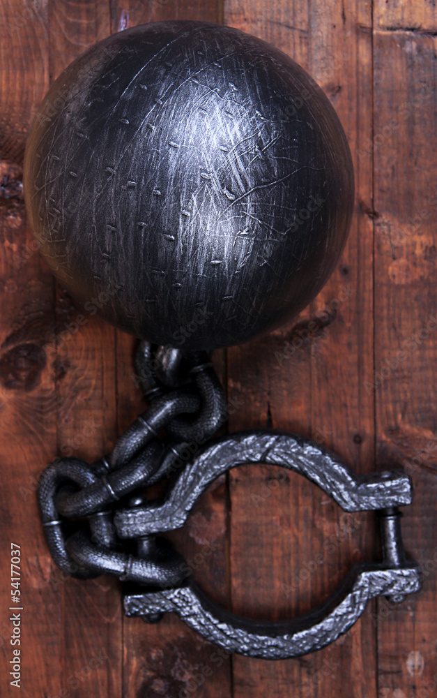 Ball and chain on wooden background Ball and chain on wooden background