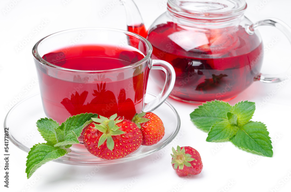 kettle and cup of red tea with strawberries and mint on a white kettle and cup of red tea with strawberries and mint on a white