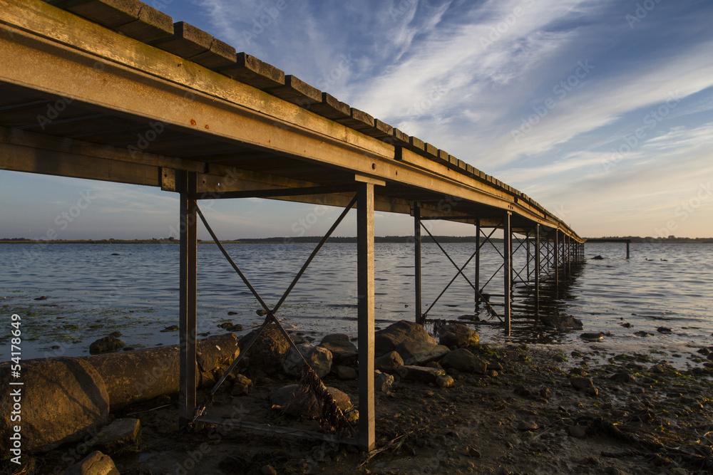 a wooden bridge extending into sea