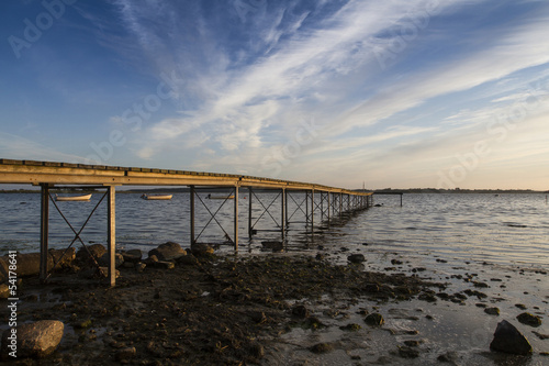 a wooden bridge extending into sea