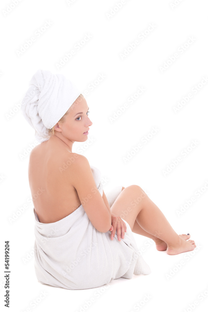 back-view of a young beautiful woman in towel sitting on white back-view of a young beautiful woman in towel sitting on white