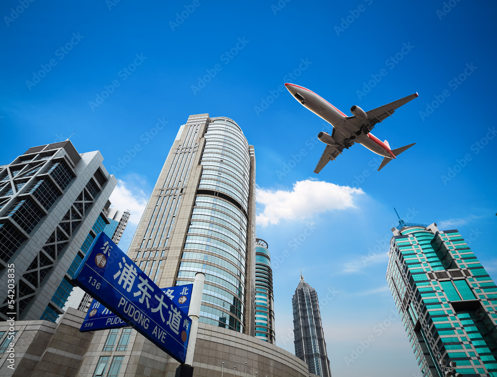 upward view airplane with modern building