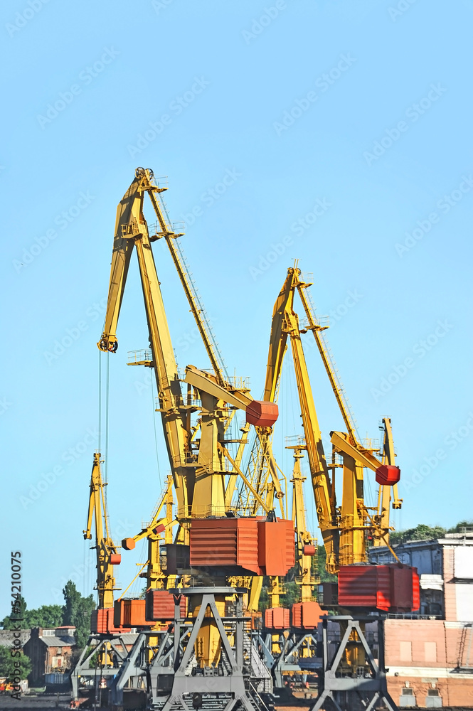 Port cargo crane over blue sky background