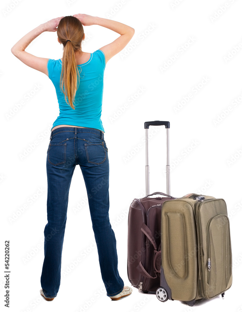 Back view of blonde woman with suitcase looking up. Back view of blonde woman with suitcase looking up.