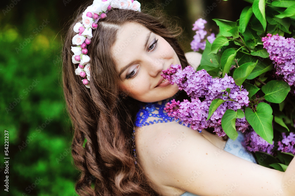Beautiful girl and blossoming lilac trees