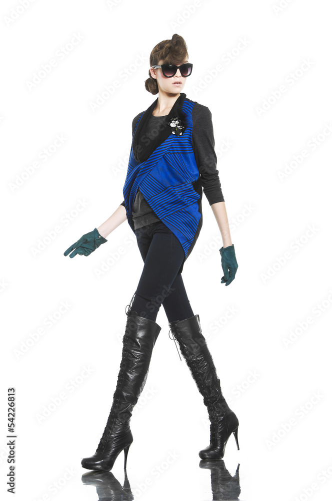 young fashion model in sunglasses with gloves walking in studio young fashion model in sunglasses with gloves walking in studio