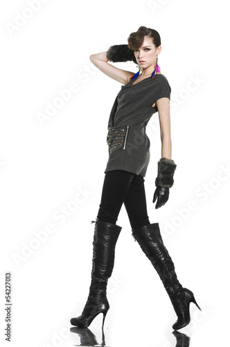 young fashion model in gloves with boots walking in studio