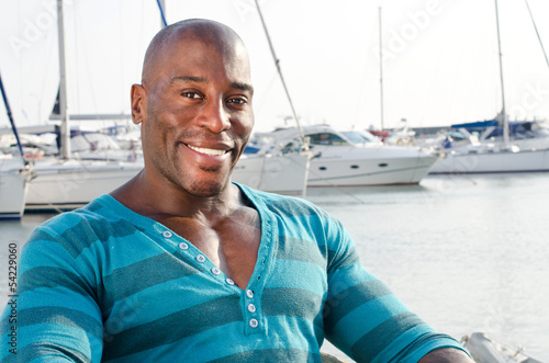 Handsome black man in a summer marine scene with yachts