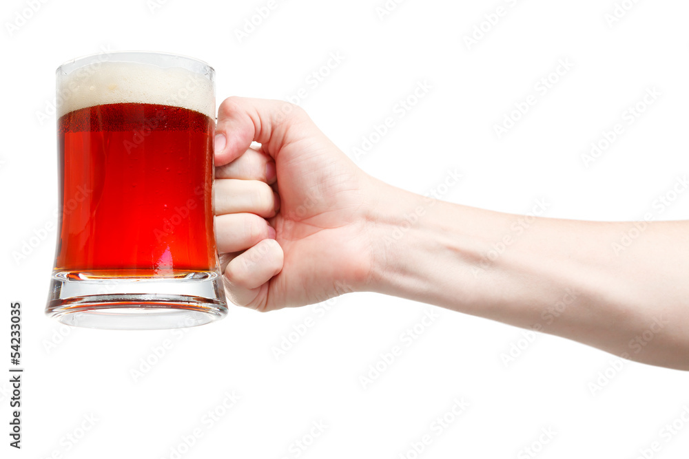 Closeup of a male hand holding up a glass of beer over a white b Closeup of a male hand holding up a glass of beer over a white b