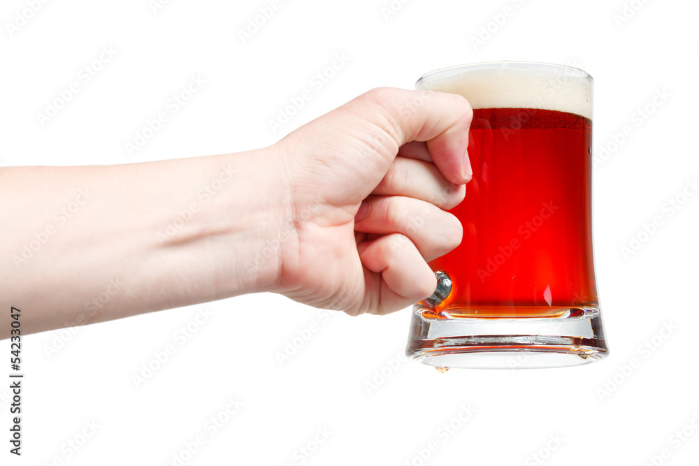Closeup of a male hand holding up a glass of beer over a white b Closeup of a male hand holding up a glass of beer over a white b
