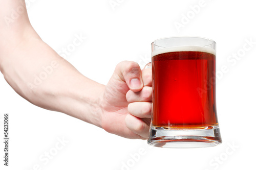 Closeup of a male hand holding up a glass of beer over a white b