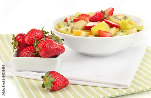 Useful fruit salad of fresh fruits and berries in bowl isolated