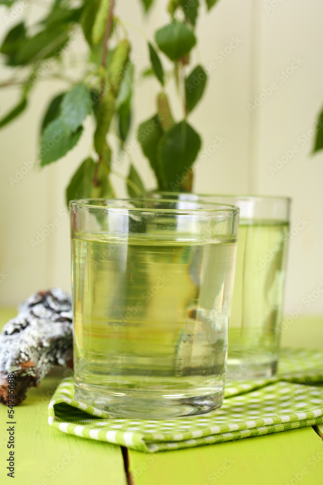 Glasses of birch sap on green wooden table Glasses of birch sap on green wooden table