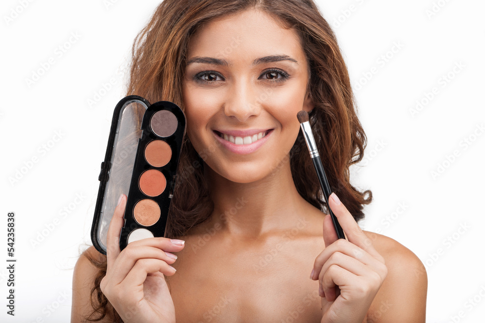 Showing her make-up stuff. Beautiful young women holding the mak Showing her make-up stuff. Beautiful young women holding the mak