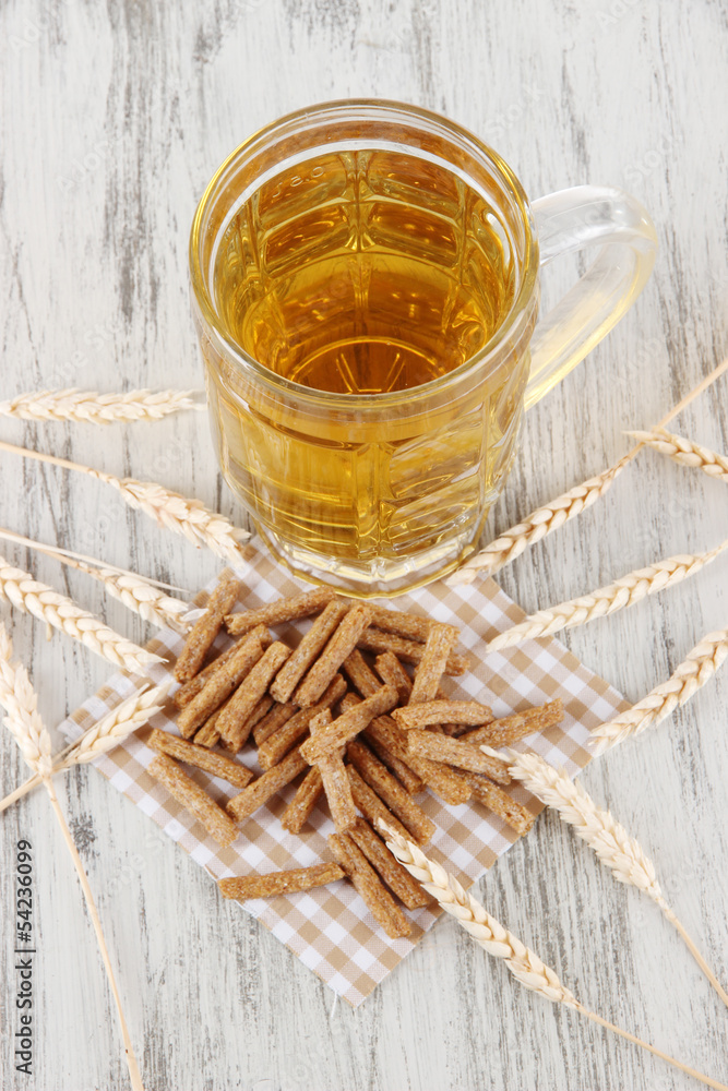 Beer in glass and crunches on napkin on wooden table Beer in glass and crunches on napkin on wooden table