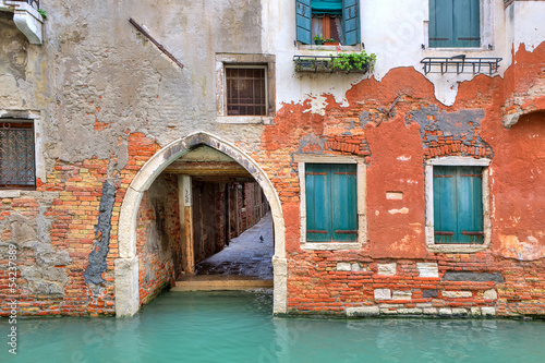 Red brick house on small canal in Venice, Italy.