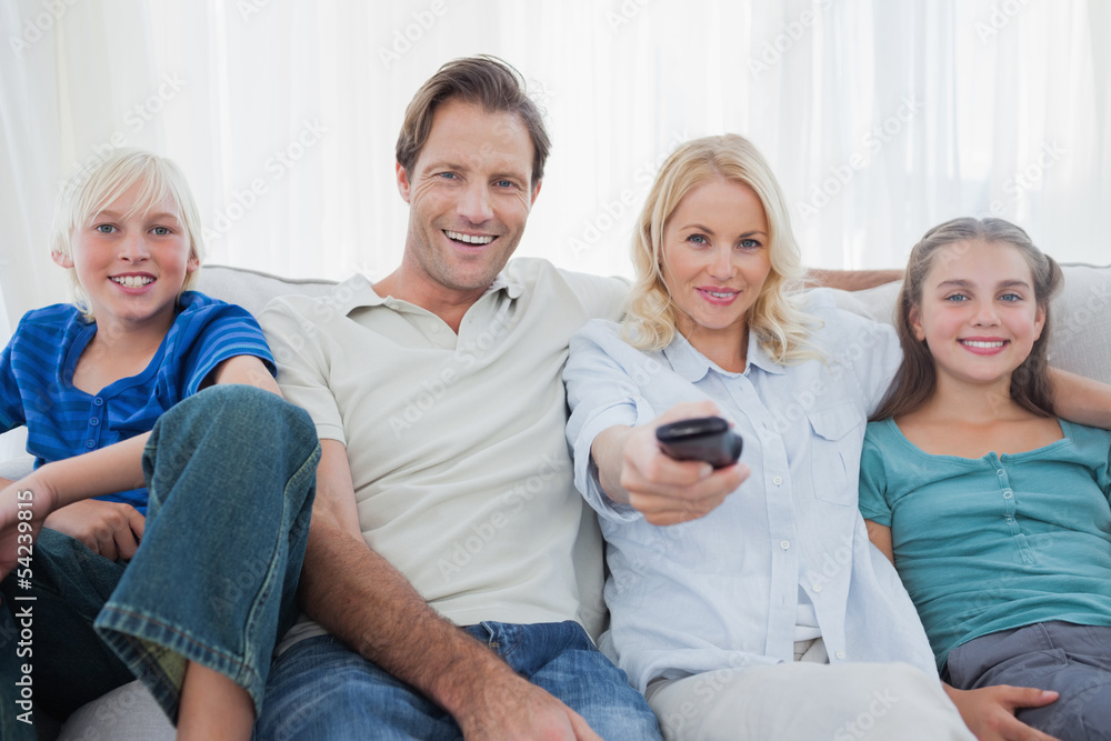 Parents posing with children and watching television Parents posing with children and watching television