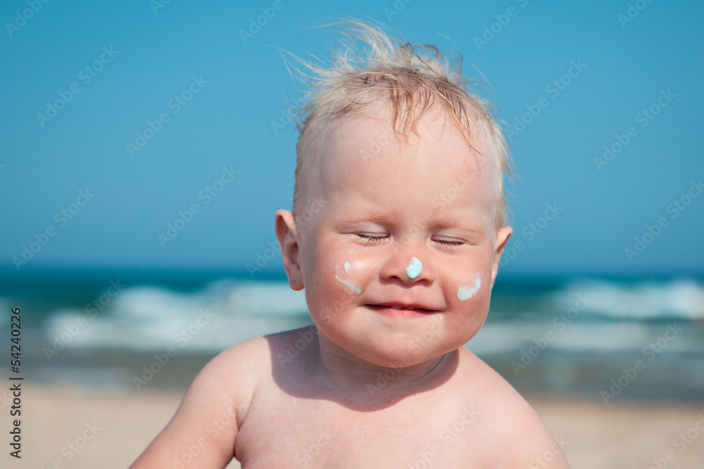 Adorable girl at beach applying sunblock cream Adorable girl at beach applying sunblock cream
