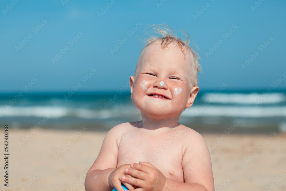 Adorable girl at beach applying sunblock cream Adorable girl at beach applying sunblock cream