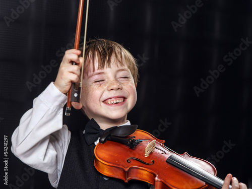 Freckled red-hair boy playing violin. photo