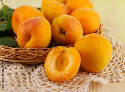 Apricots on wicker coasters on napkin on wooden table